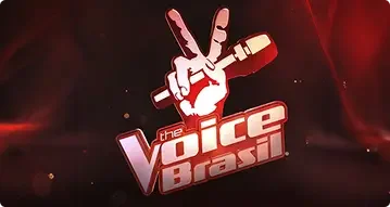 O logotipo do The Voice Brasil apresenta uma mão estilizada segurando um microfone, com dois dedos levantados em sinal de paz e contornos em branco e vermelho. Abaixo, o nome The Voice Brasil aparece em letras marcantes sobre um fundo vermelho escuro e vibrante. Esta imagem faz parte do portal da Tecnogera.