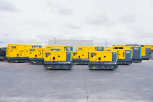 Vários geradores amarelos da Tecnogera estão alinhados para garantir energia contínua em setores que não podem parar, mesmo em dias nublados
