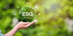 Na imagem, uma mão segura um globo verde brilhante com "ESG". Ícones ao redor ilustram a sustentabilidade.